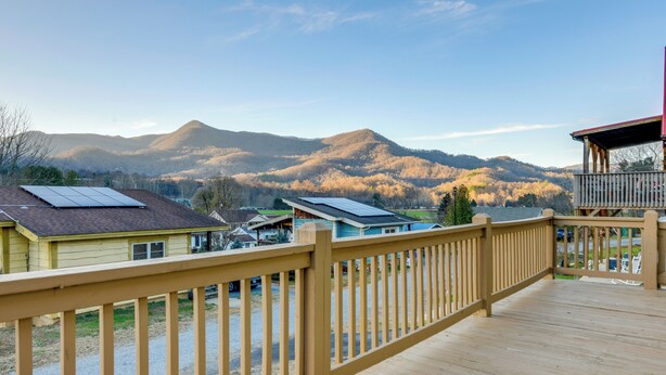 A wooden deck with a view of houses and mountains. - Waynesville Cabin Rental w/ Mountain Views (Waynesville)