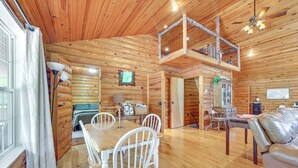 A wooden cabin interior with a dining area, a loft bedroom, and a living room. - Kentucky Group Getaway w/ Dock + Lake Access (Burnside)
