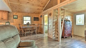 A wooden interior with a dining table, chairs, a sofa, and a dresser. - Waterfront Syracuse Home: Deck, Fire Pit & Kayaks (Syracuse)