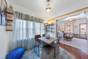 Relax in a stylish living room with a dining table, comfortable seating area, and plenty of natural light.