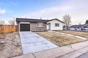A single-story house with a garage, a front lawn, and a wooden fence. - Bright & Modern Arvada Home w/ Yard & Patio (Westminster)