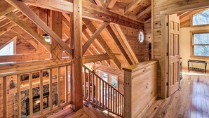 A wooden interior with a stone fireplace, wooden beams, and a staircase. - 4 Mi to Sugar Mtn: 'rocky Creek Cabin' w/ Hot Tub (Banner Elk)
