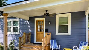 A porch with a wooden staircase, a ceiling fan, and two chairs. - Central Cottage w/ Grill, 1 Mi to Cajun Field (Lafayette)