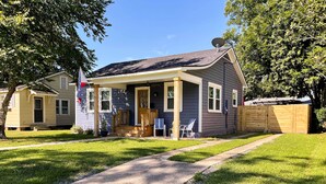 A two-story house with a front porch, a satellite dish, and a wooden fence. - Central Cottage w/ Grill, 1 Mi to Cajun Field (Lafayette)