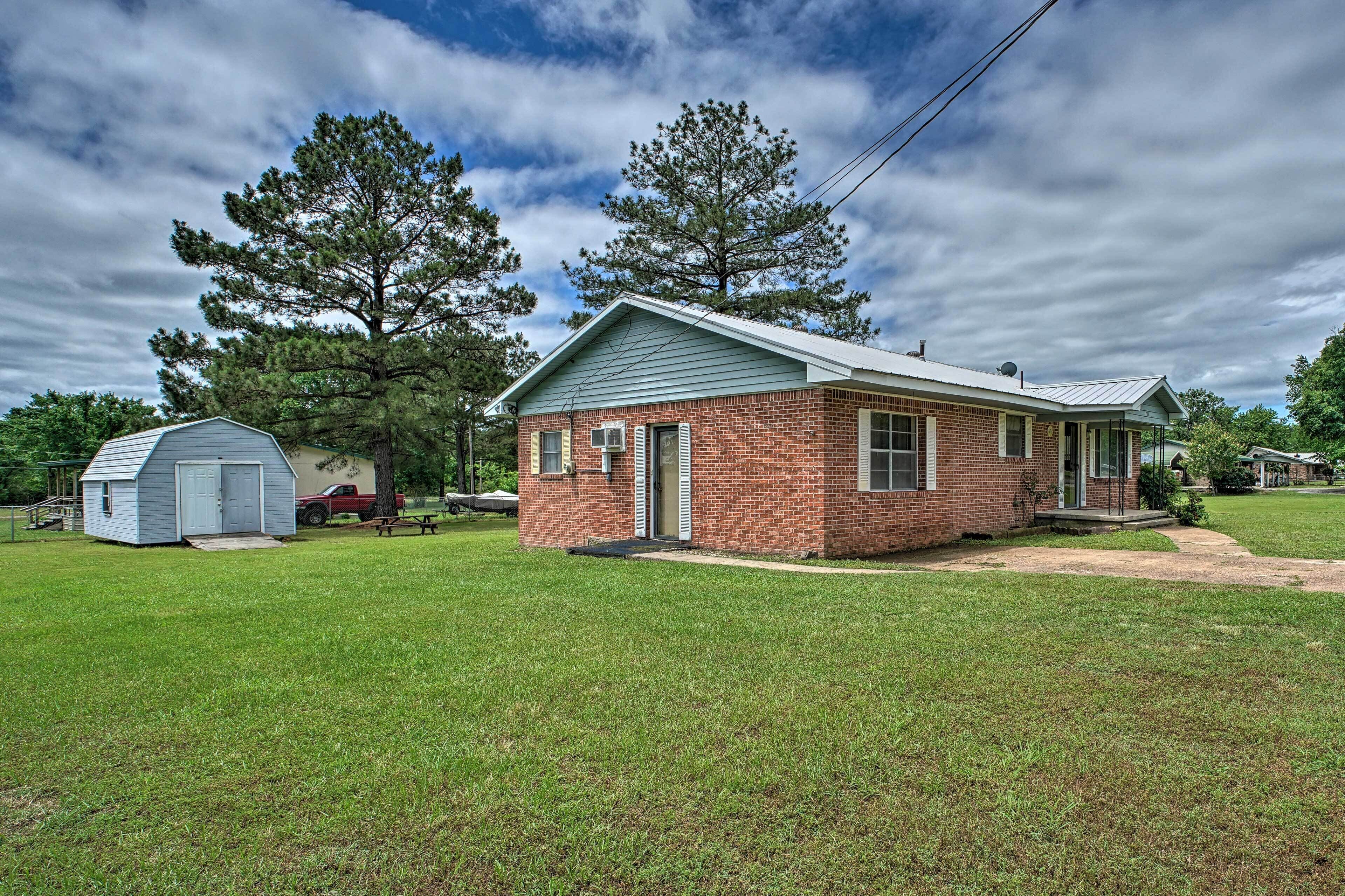 A single-story brick house with a gabled roof, a small attached garage, and a well-maintained lawn.