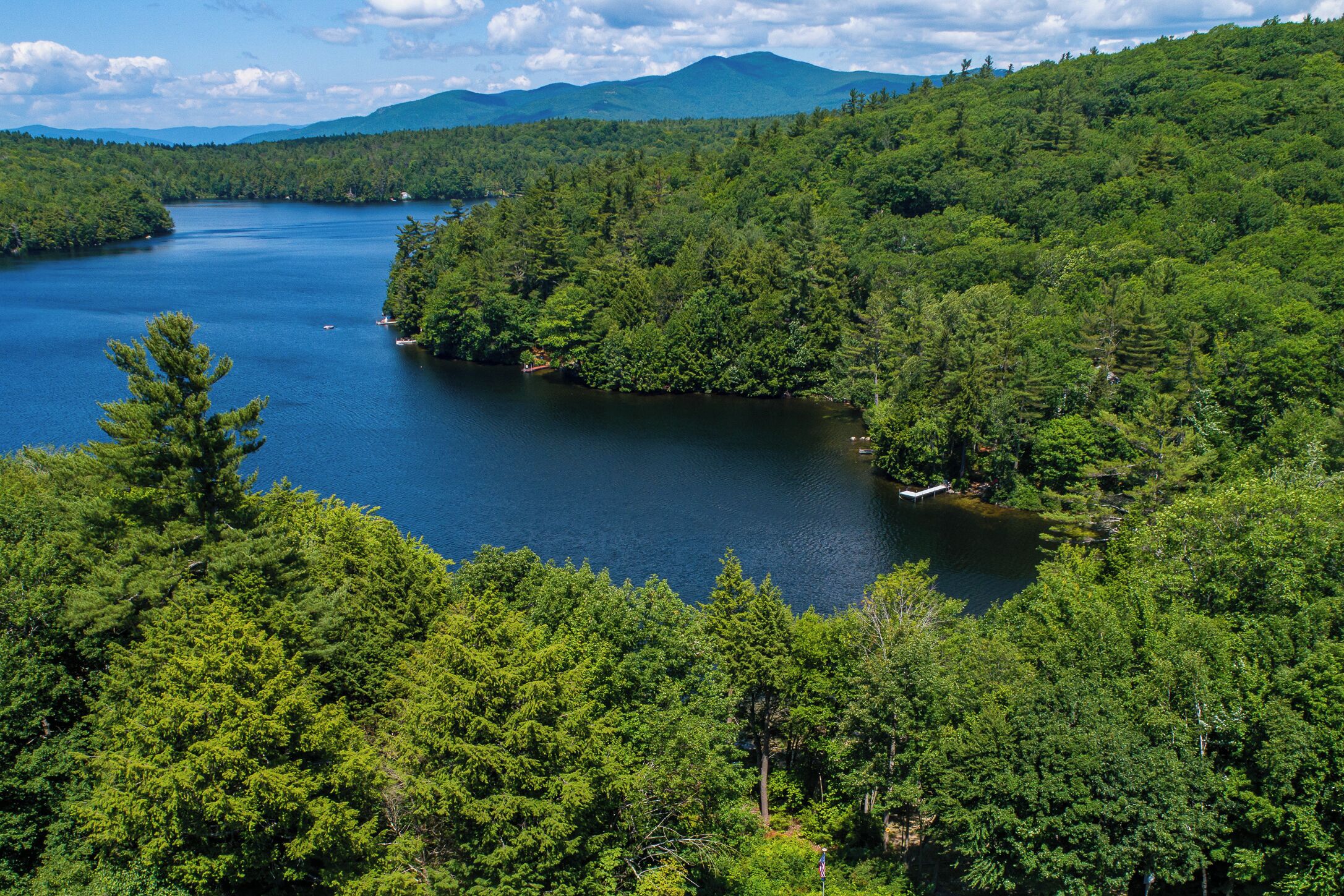 A lake surrounded by dense forest and mountains.