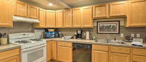 A modern kitchen with wooden cabinets, stainless steel appliances, and a large island.
