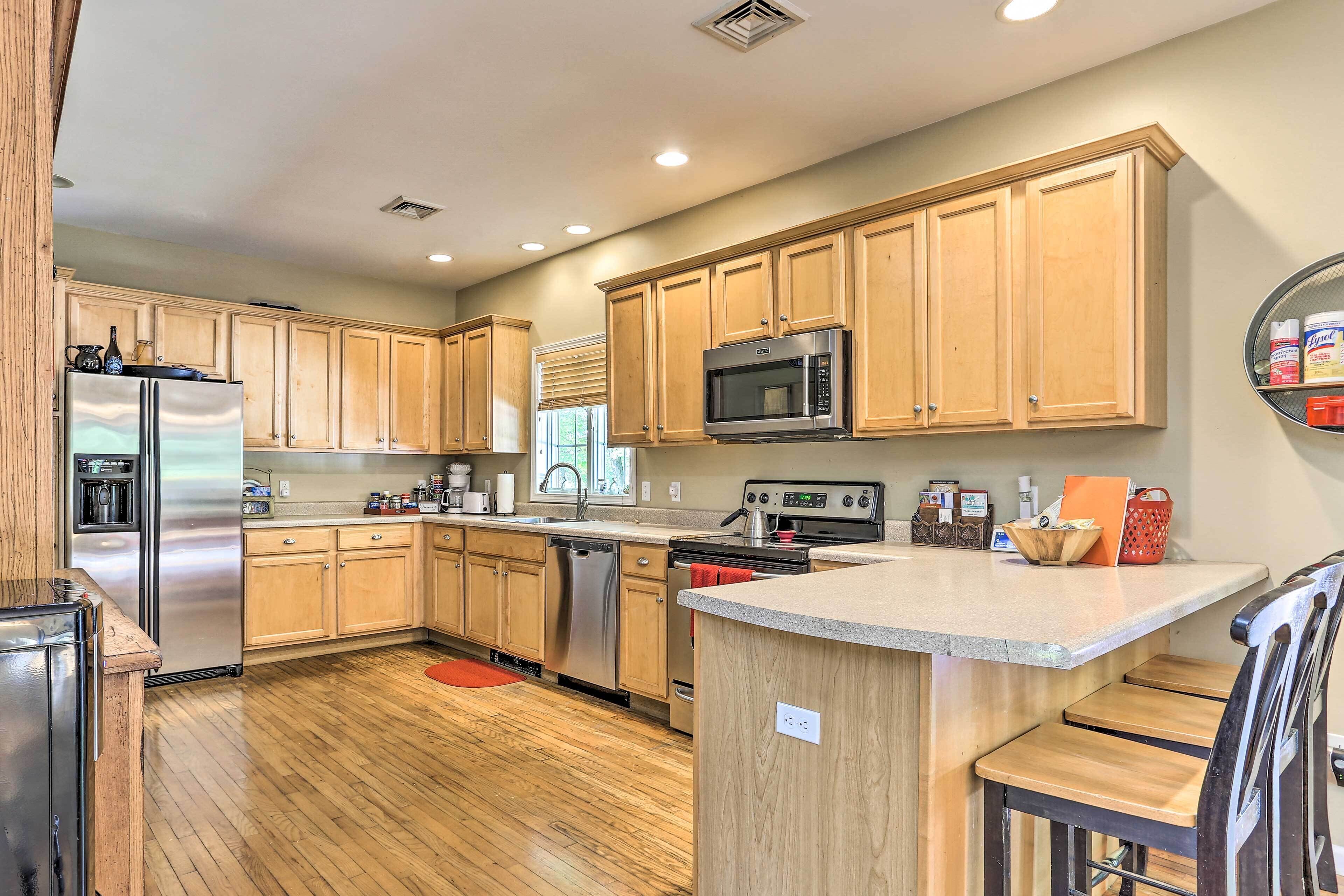 A modern kitchen with wooden cabinets, stainless steel appliances, and a central island.