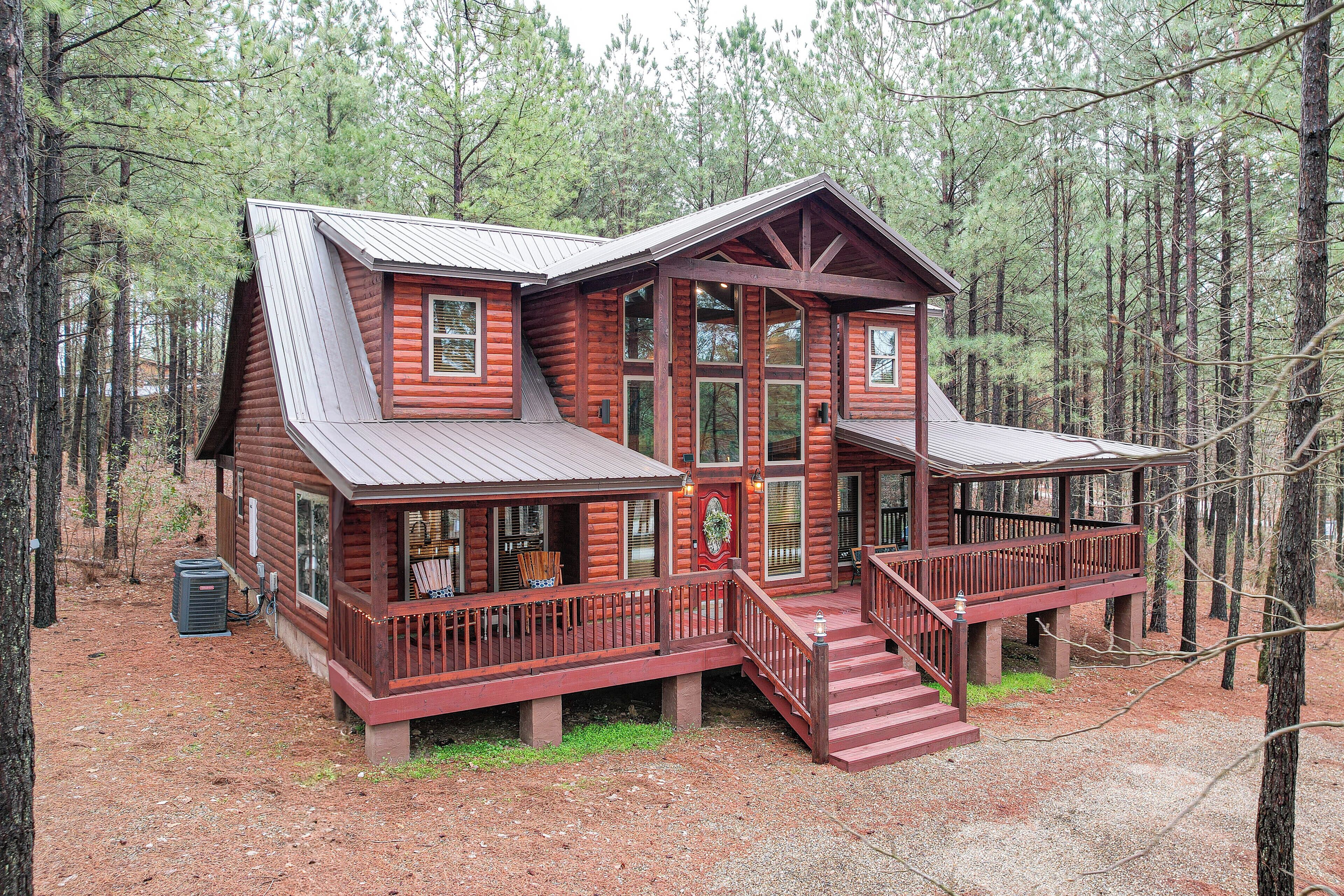 A log cabin with a porch, multiple windows, and a staircase leading to the entrance.