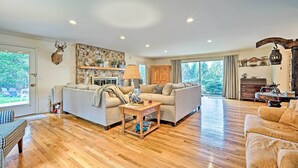 A spacious living room with a wooden floor, two sofas, a coffee table, and a fireplace. - Family Winter Retreat w/ Hot Tub: 14 Mi to Slopes! (Whitingham)