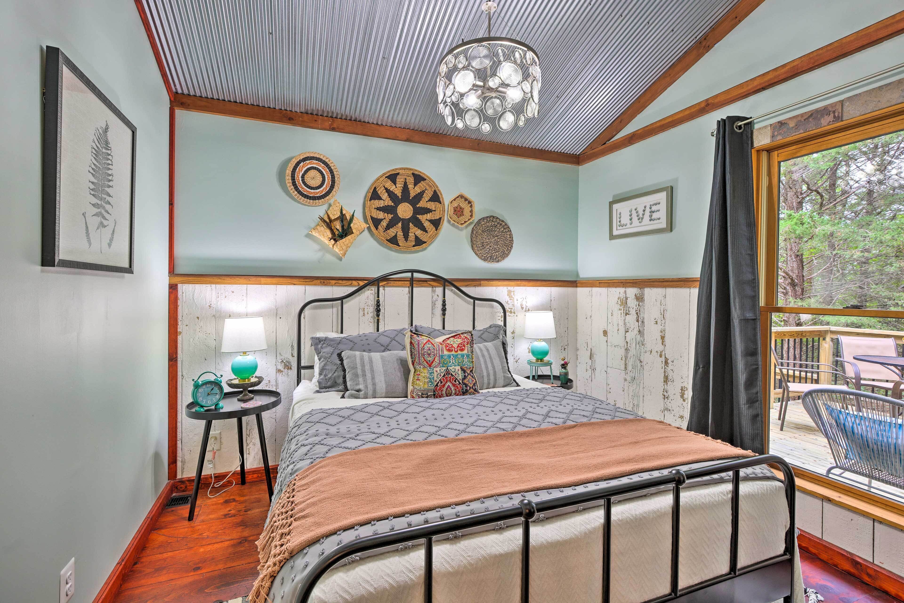 Un dormitorio con cama, mesitas de noche, decoración en la pared y vistas al exterior.