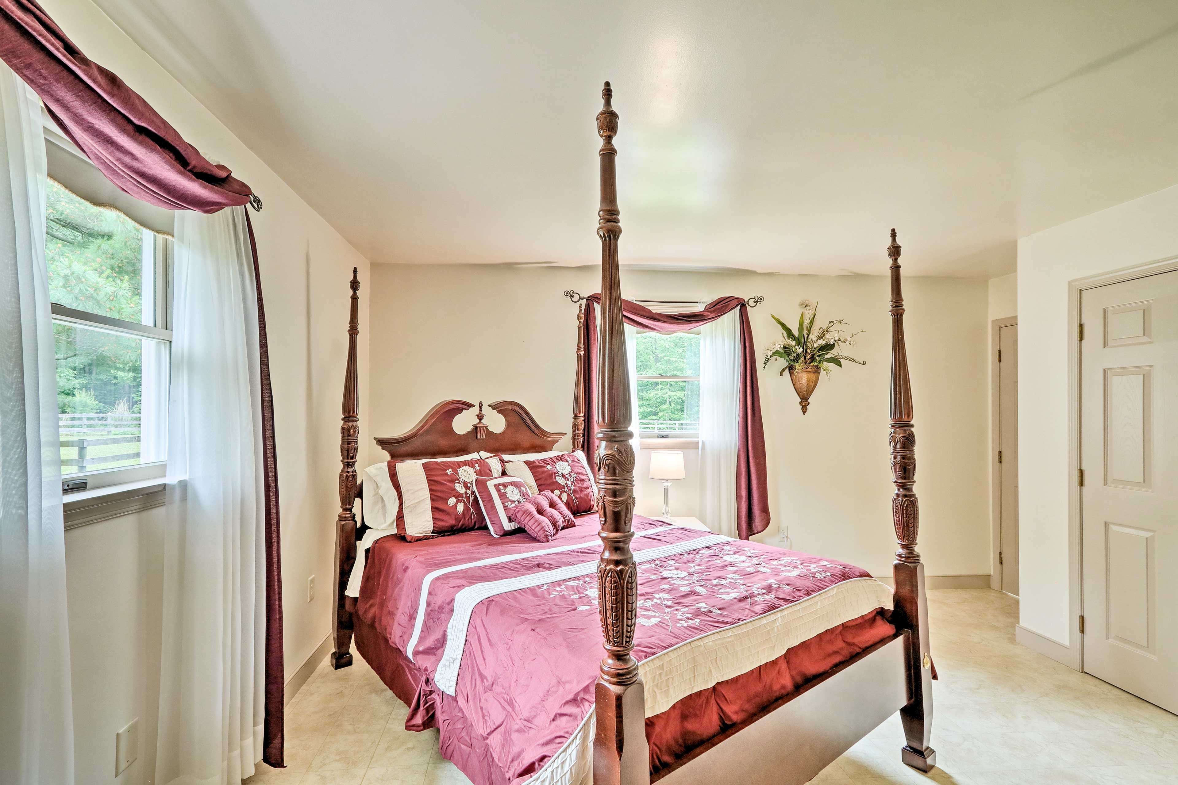A four-poster bed with a wooden headboard, a red and white bedspread, and matching pillows.