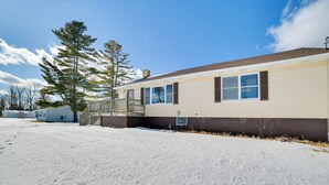 A single-story building with a flat roof, a covered porch, and a snow-covered ground.
