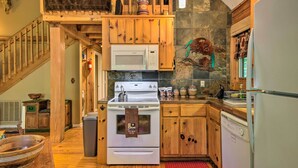 Une cuisine avec des meubles de rangement en bois, un four à micro-ondes, une cuisinière et un lave-vaisselle.