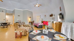A spacious living area with a dining table set for two, a sofa, and a kitchen area in the background. - Remote Angie Vacation Rental Near Pearl River! (Angie)