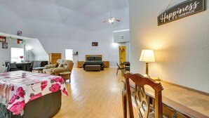 A spacious room with a dining table, a sofa, a bed, and a ceiling fan. - Remote Angie Vacation Rental Near Pearl River! (Angie)