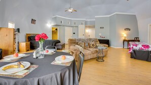 A spacious living area with a dining table set for two, a sofa, and a ceiling fan. - Remote Angie Vacation Rental Near Pearl River! (Angie)