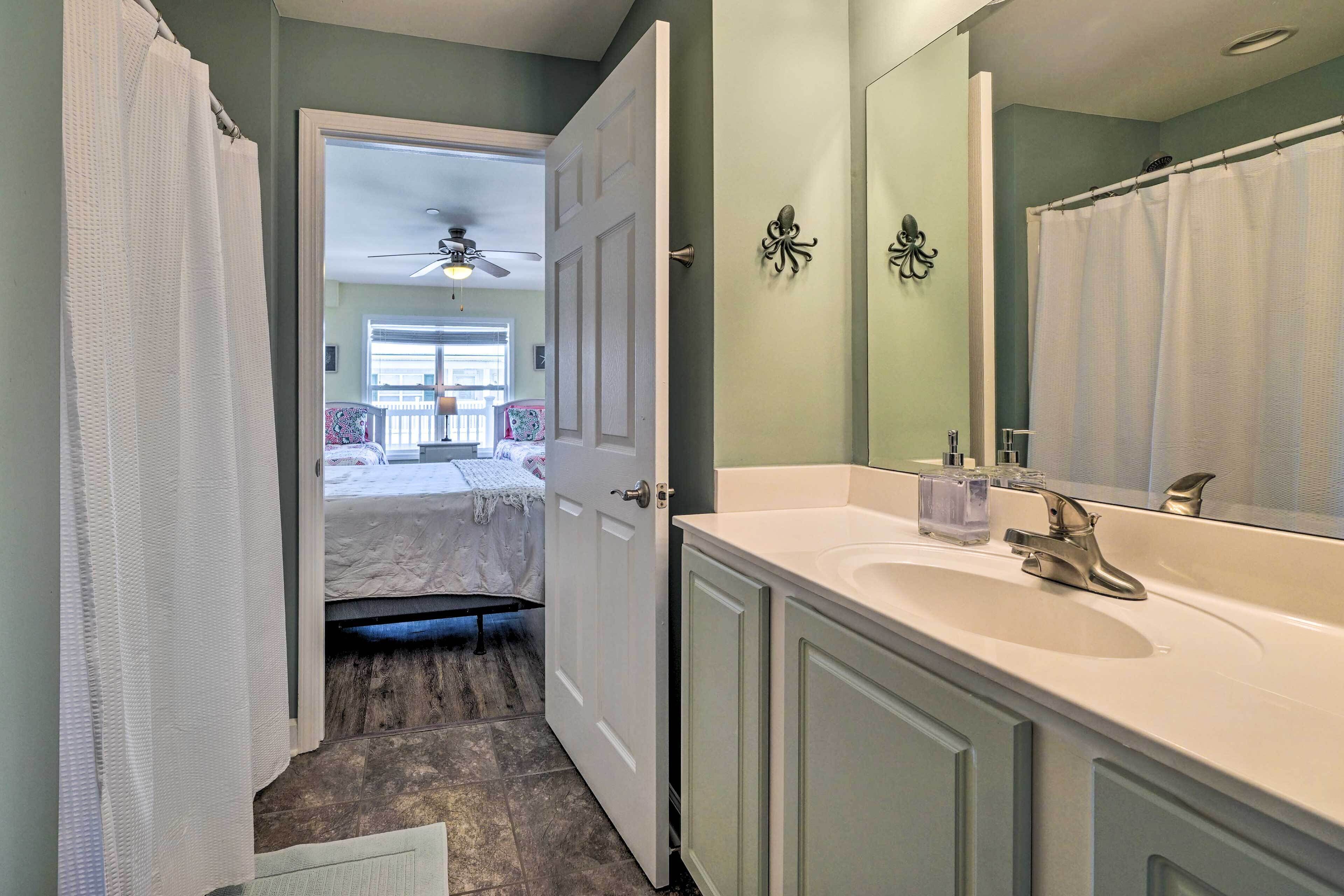 A bathroom with a white sink, a large mirror, and a shower curtain.