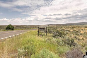 Un cartello per 'Yosemite's Jewelry Ranch' in un paesaggio rurale con una strada e vegetazione rada.