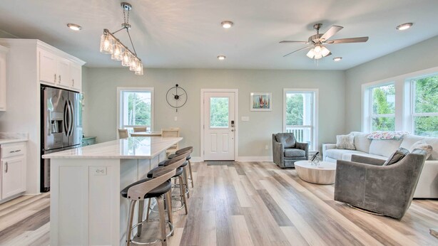 A spacious kitchen with a central island, bar stools, and a dining area.