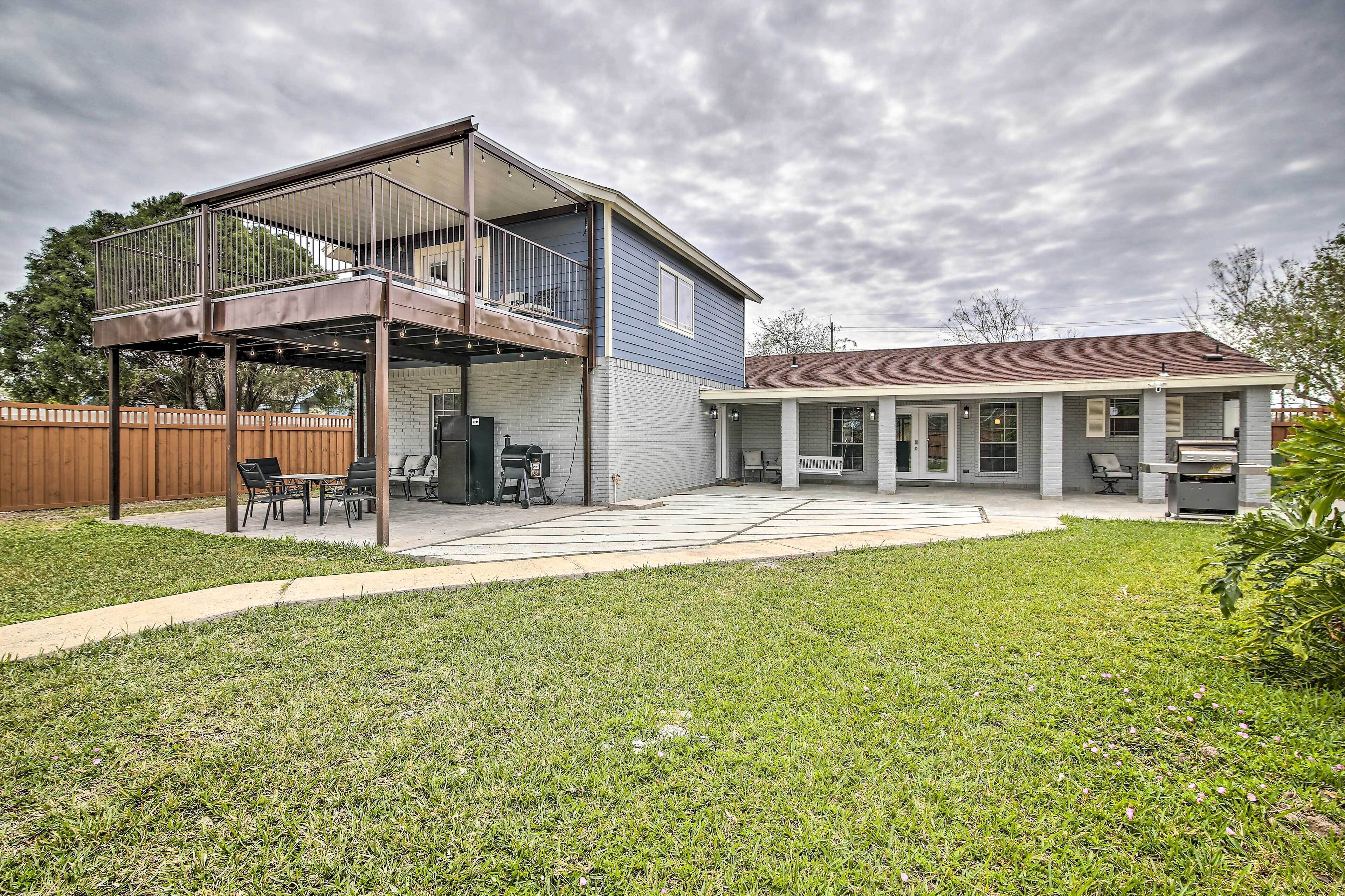 Een tweelaags huis met een overdekt terras en een omheinde achtertuin.