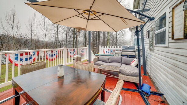 A covered outdoor deck with a table and chairs, a sofa, and an umbrella. - Pet-friendly Apollo Home w/ Furnished Deck! (Apollo)