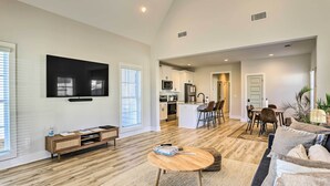 A spacious living room with a flat-screen TV, wooden flooring, and a cozy seating area with a coffee table. - Opelika Townhome w/ Central A/C + Heating! (Opelika)