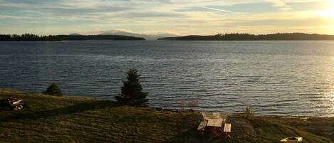 A lakeside view with a wooden bench and canoes.