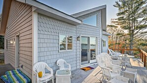 A modern house with a deck, white wicker furniture, and a large window. - 2BR Coastal Gem! Breathtaking Ocean/mountain View (Sullivan)