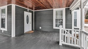 A covered porch with a wooden ceiling, a white railing, and a gray exterior wall. - Walkable Sodus Point Retreat < 1 Mi to Lake (Sodus Point)