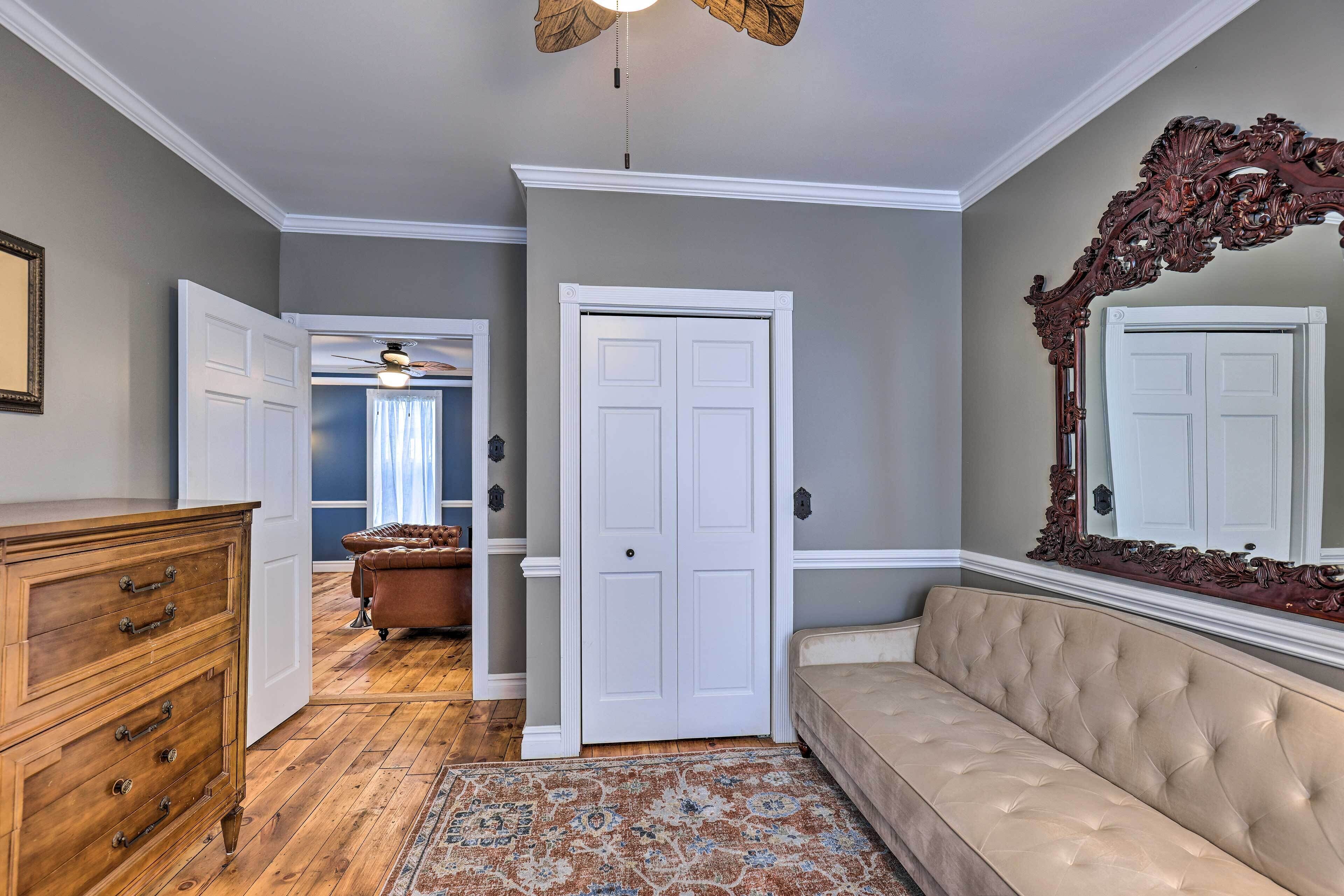A hallway with a wooden dresser, a beige sofa, and a patterned rug.