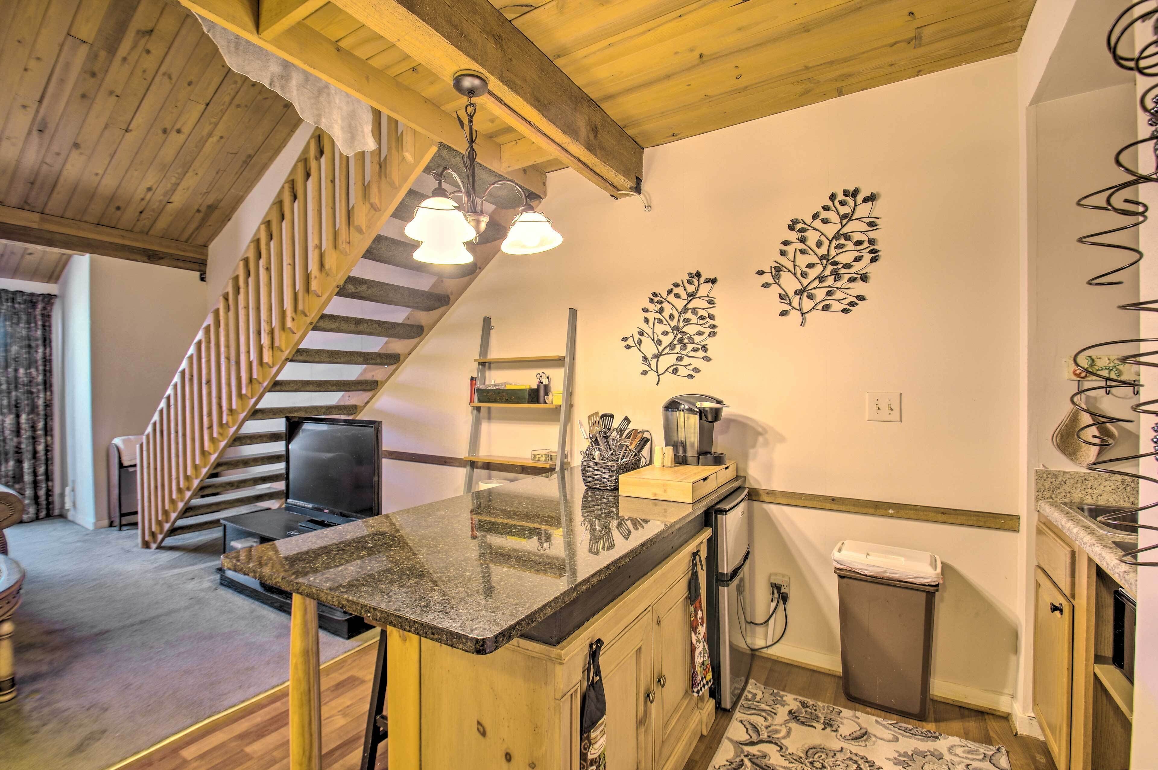 A kitchen with wooden cabinets, a granite countertop, a built-in stove, and a stainless steel sink.