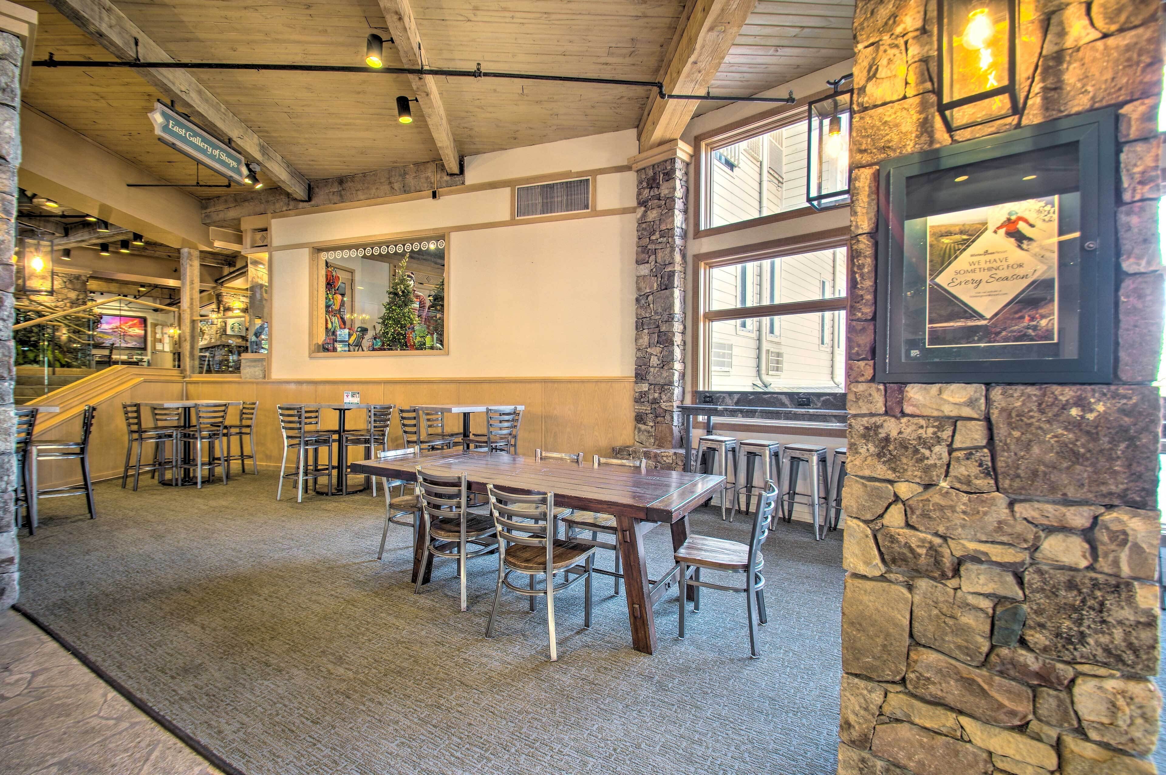 Un restaurante con pared de piedra, mesas y sillas de madera.