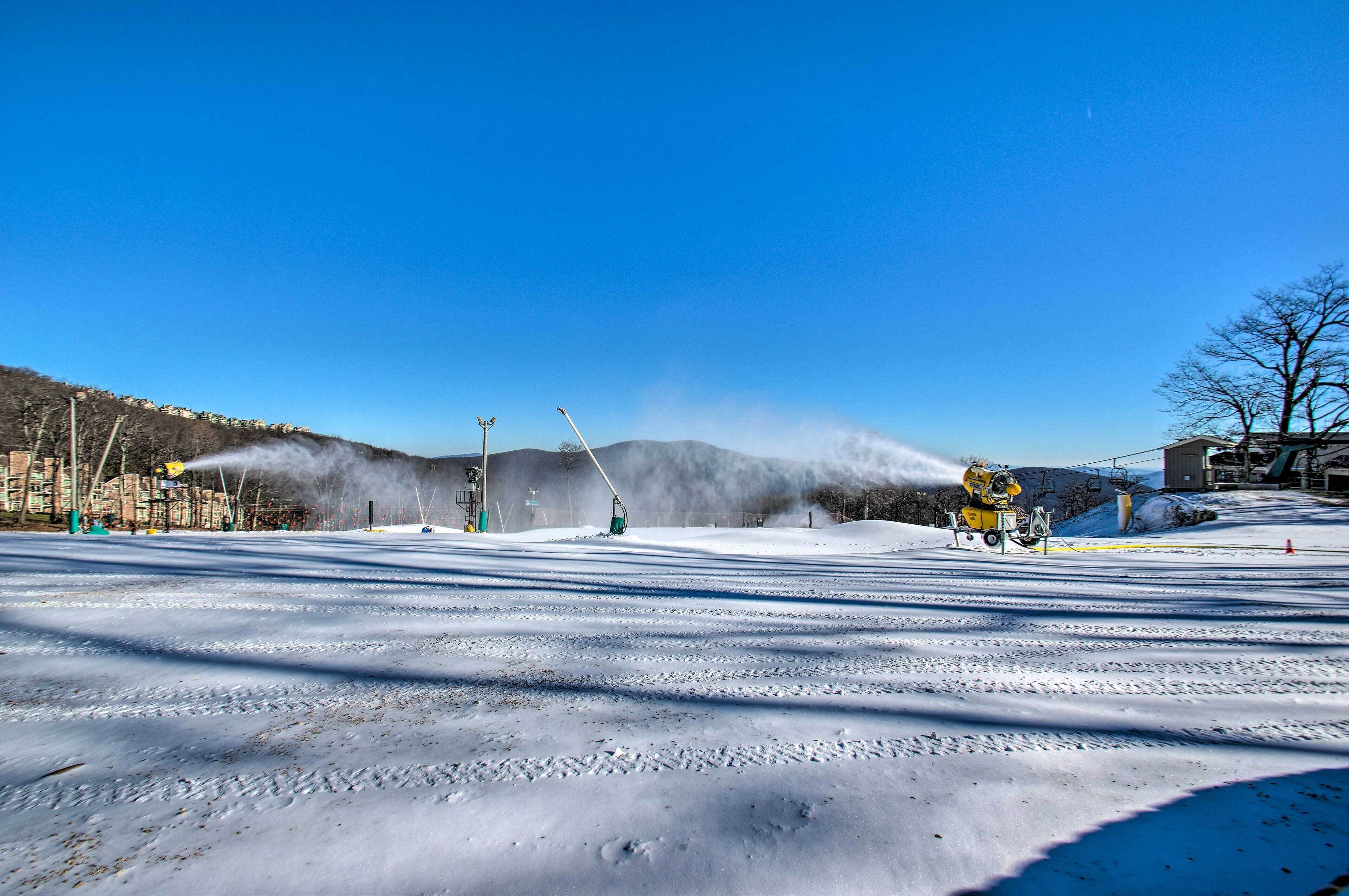 Pista de esquí nevada con remontes y una montaña al fondo.