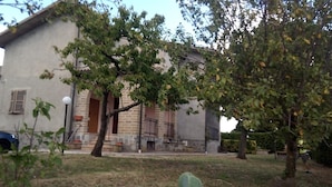 A two-story building with a stone facade, a visible entrance, and a small porch area. - PANORAMIC VILLA (Bagnoregio)