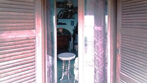 A narrow hallway with wooden shutters, a small round table, and a hanging lamp. - PANORAMIC VILLA (Bagnoregio)