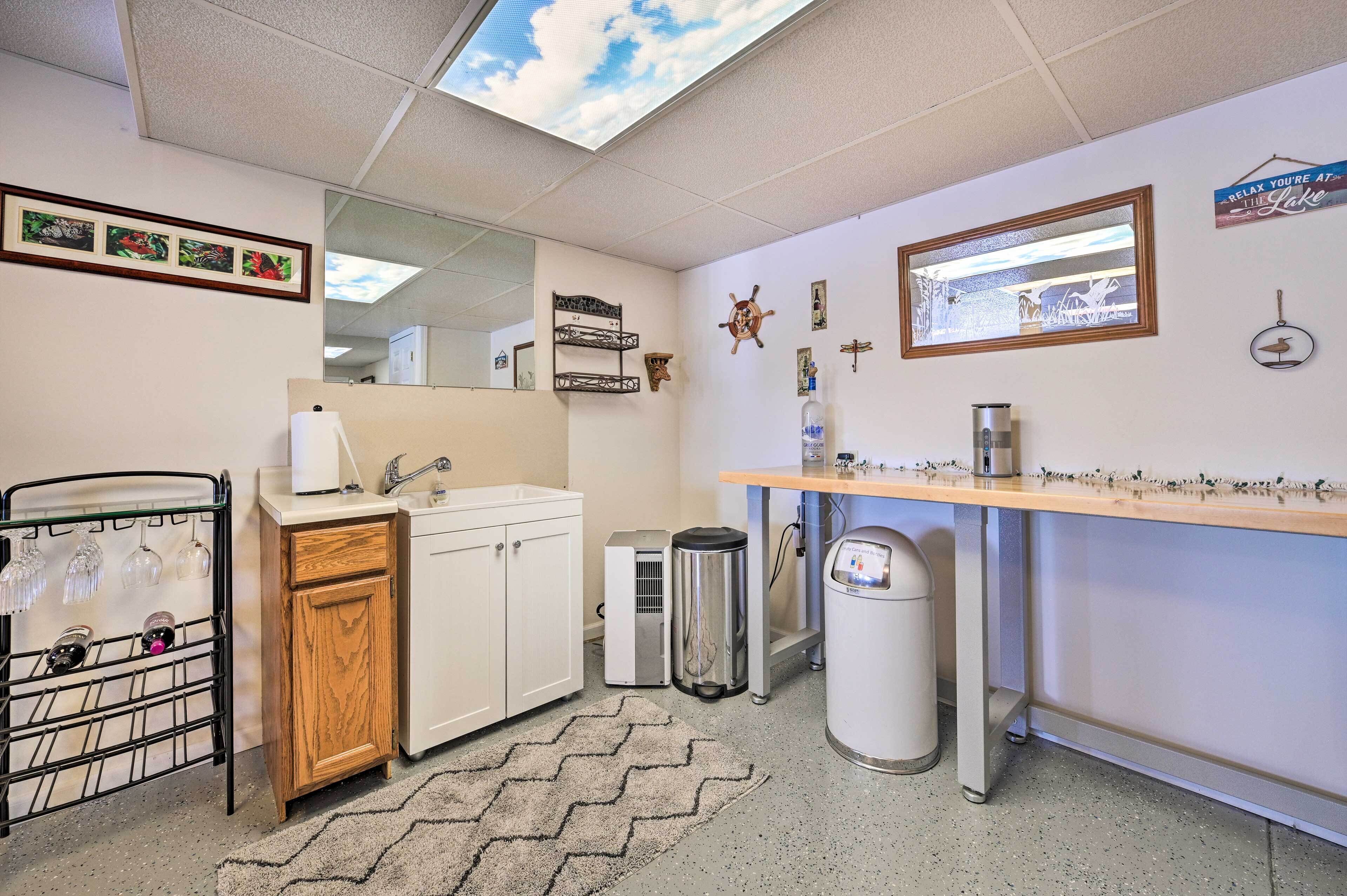 A compact hotel bathroom with a sink, mirror, and a small window.