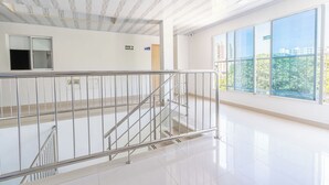 A spacious indoor area with a staircase, large windows, and a clean, modern design. - Hotel Perla Del Caribe (Santa Marta)