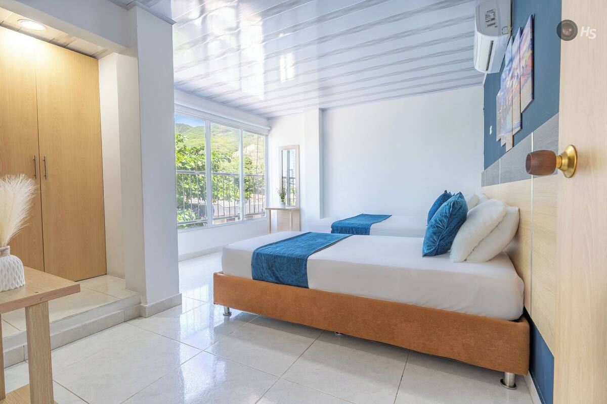 Une chambre moderne avec un grand lit, une armoire en bois et une vue sur la verdure.