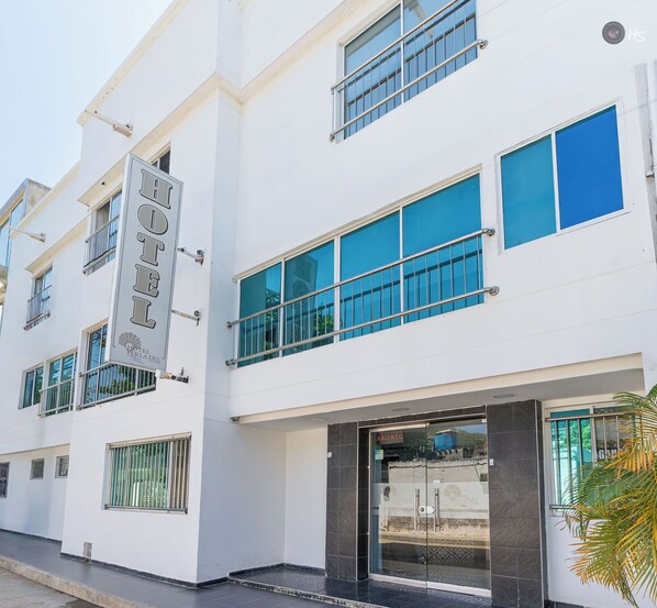 A modern hotel with a prominent sign, large windows, and a glass entrance. - Hotel Perla Del Caribe (Santa Marta)