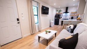 Una sala de estar moderna con un sofá, una mesa de centro y un televisor.