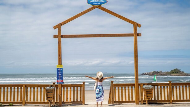 A wooden structure with a sign reading "PITANGUEIRAS" and a beach view. - Hotel Nacional Inn Guarujá (Guarujá)
