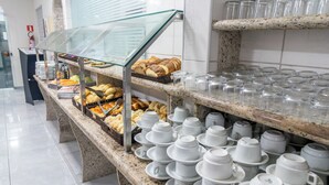 A buffet area with various food items and a glass display case. - Hotel Nacional Inn Guarujá (Guarujá)
