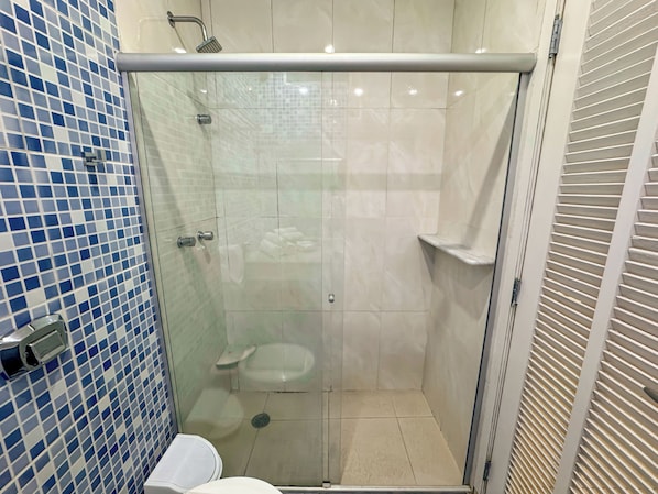 A glass-enclosed shower stall with a toilet and a sink. - Hotel Nacional Inn Guarujá (Guarujá)