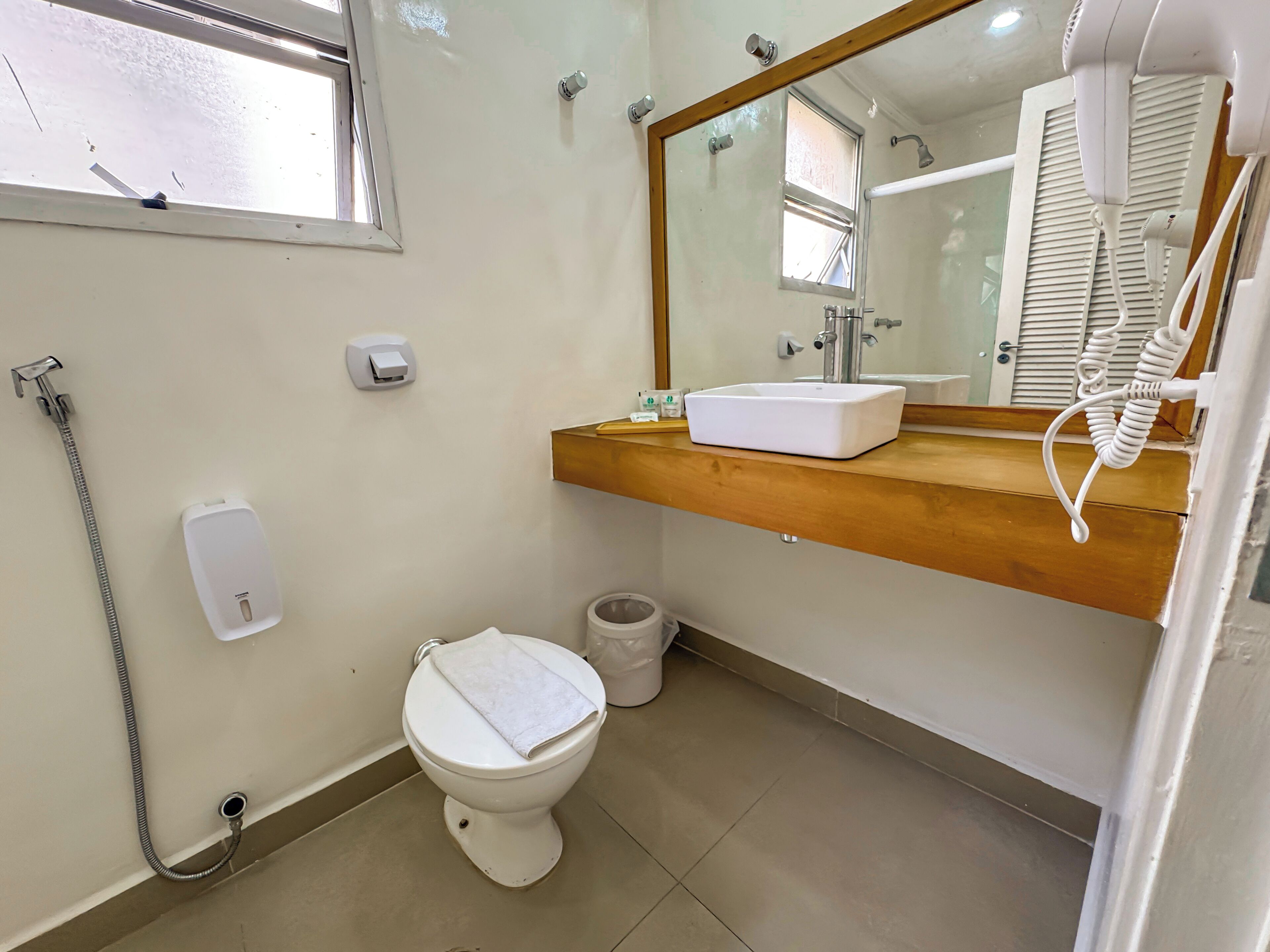 Une salle de bain avec des toilettes, un lavabo et un miroir.
