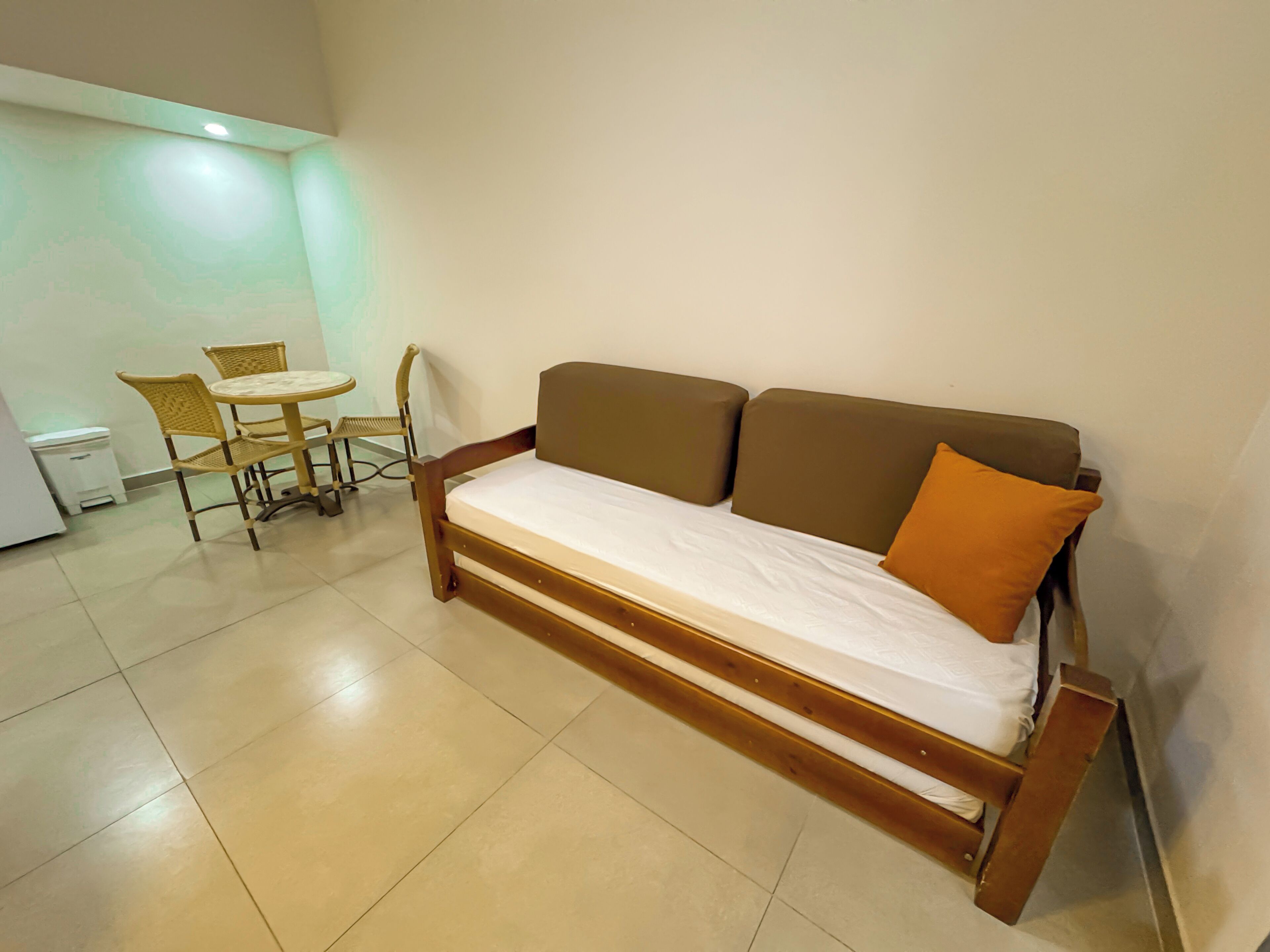 A compact room with a single bed, a small table, and two chairs.