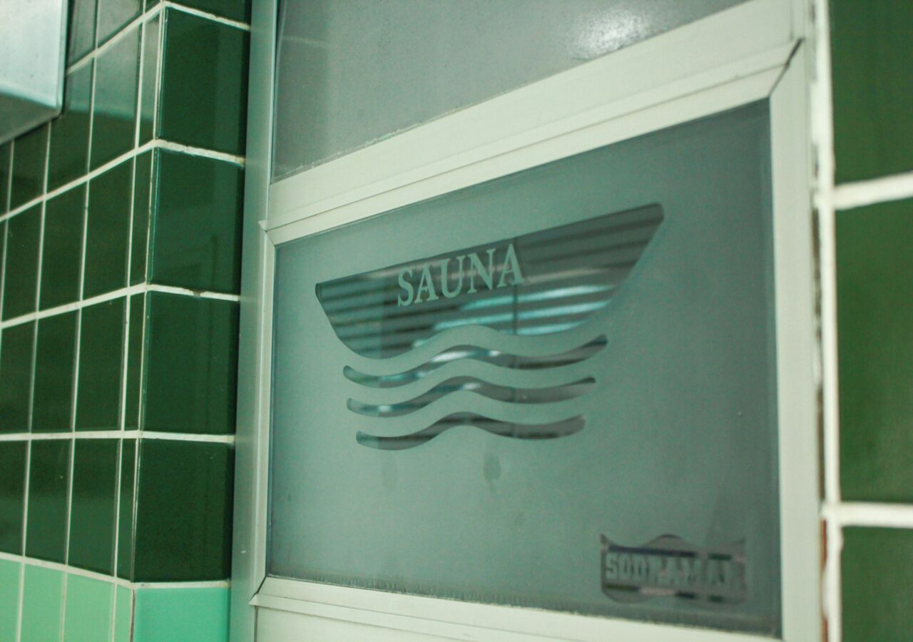 Une fenêtre avec une enseigne indiquant « SAUNA » et un motif ondulé en dessous.