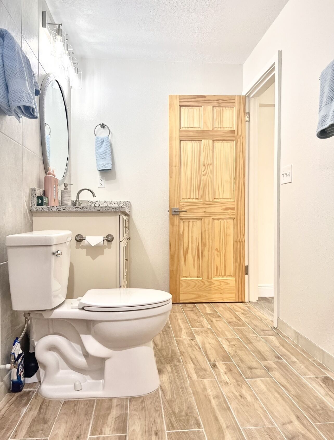 Une salle de bain avec des toilettes, un lavabo et une porte en bois.