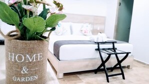 Un dormitorio con cama, mesita de noche y una planta en maceta.