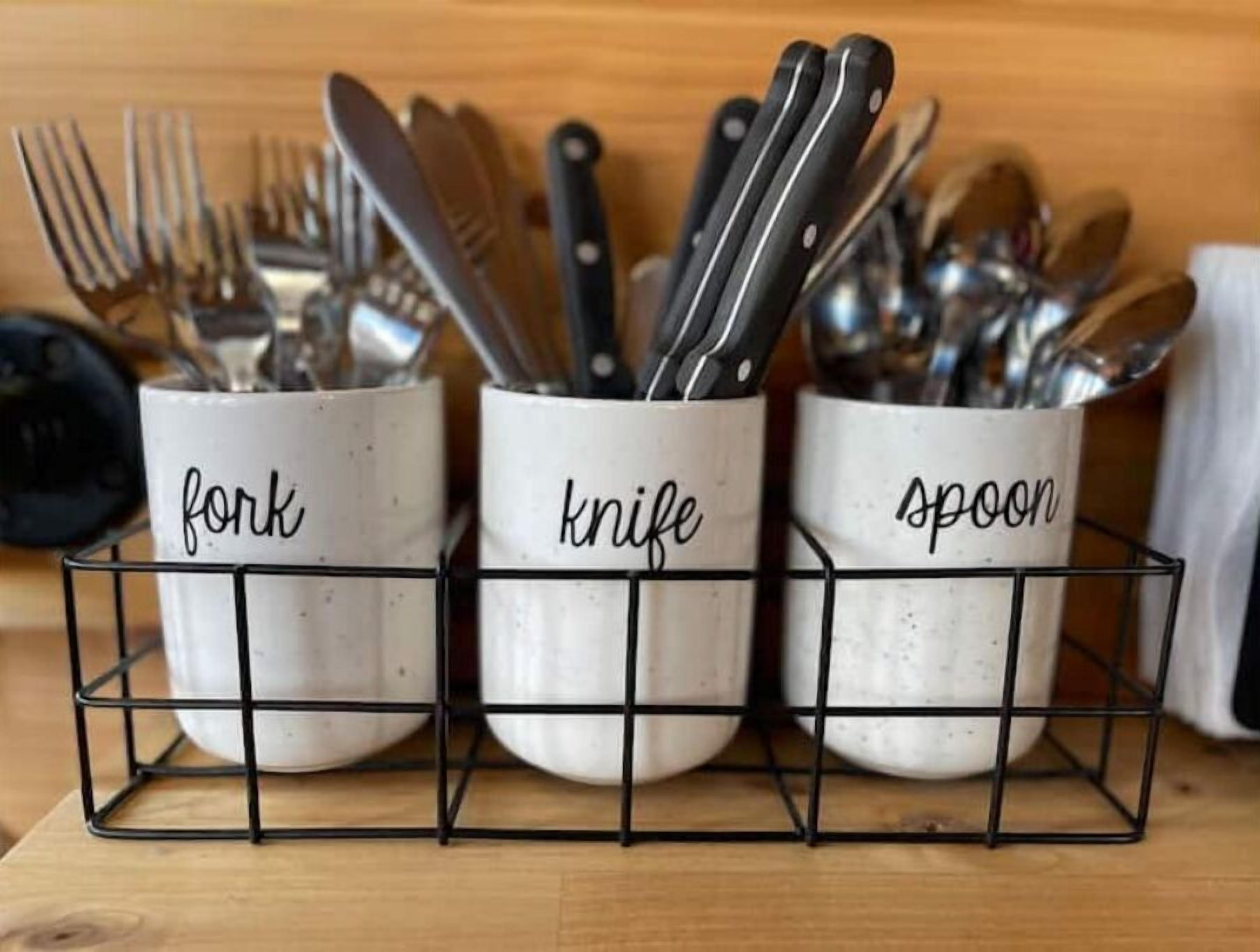 Three kitchen utensil holders labeled 'fork,' 'knife,' and 'spoon' on a wooden surface.